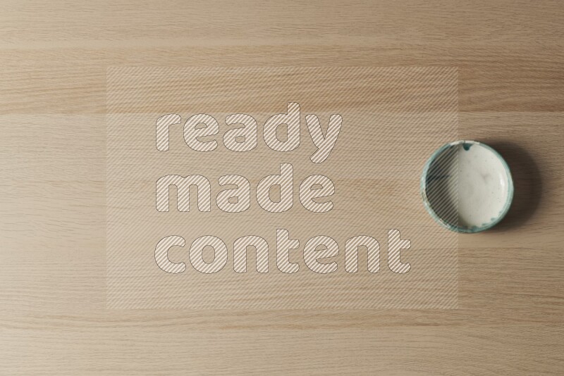 وعاء فخاري متعدد الألوان على خلفية خشبية فاتحة