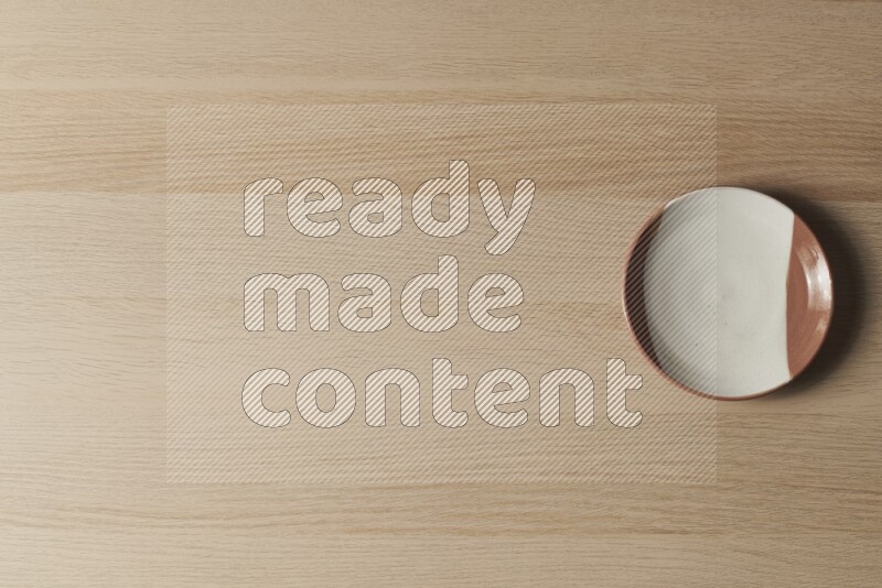 A multicolored pottery plate on light wooden background