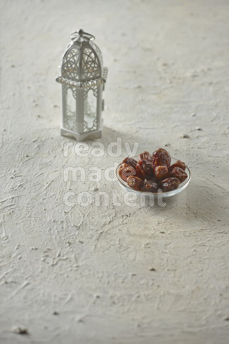A white lantern with different drinks, dates, nuts, prayer beads and quran on white background
