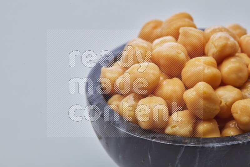 Close up of a boiled chickpeas in a container on white background