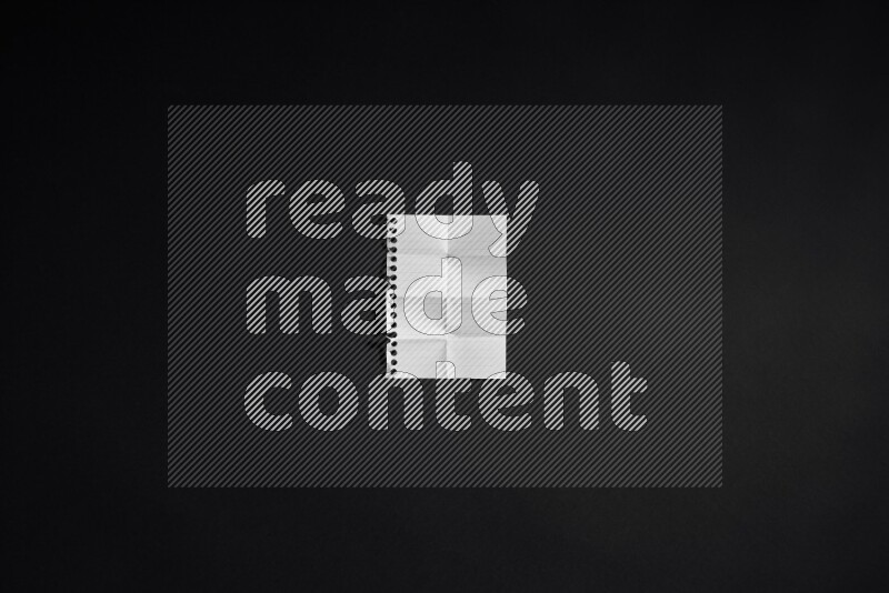 Folded notebook sheet on black background