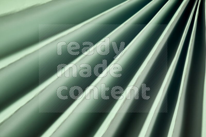 An image presenting an abstract paper pattern of lines in green and gold tones