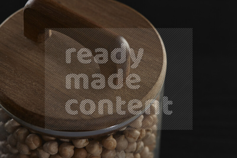 Chickpeas in a glass jar on black background