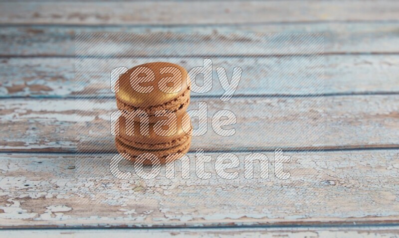 45º Shot of two Brown Coffee macarons on light blue wooden background