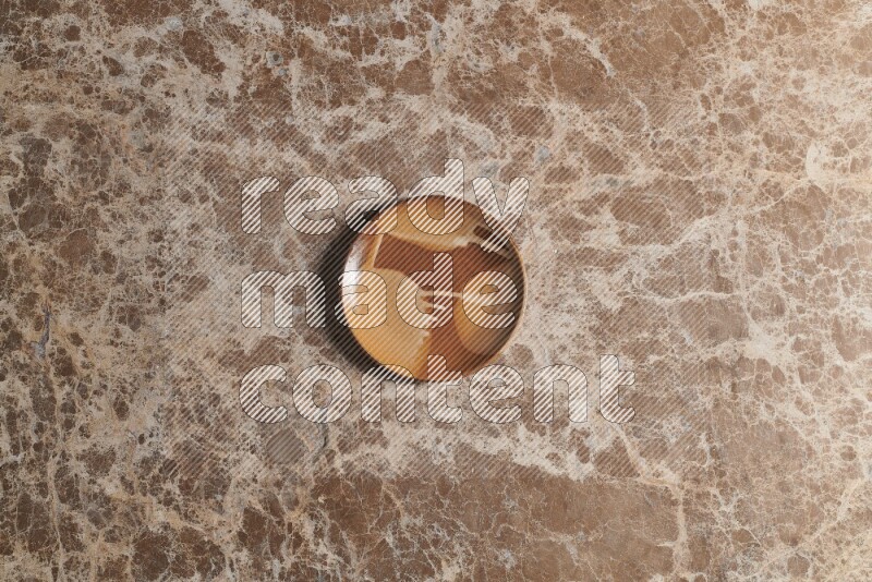 A multicolored pottery plate on beige marble background