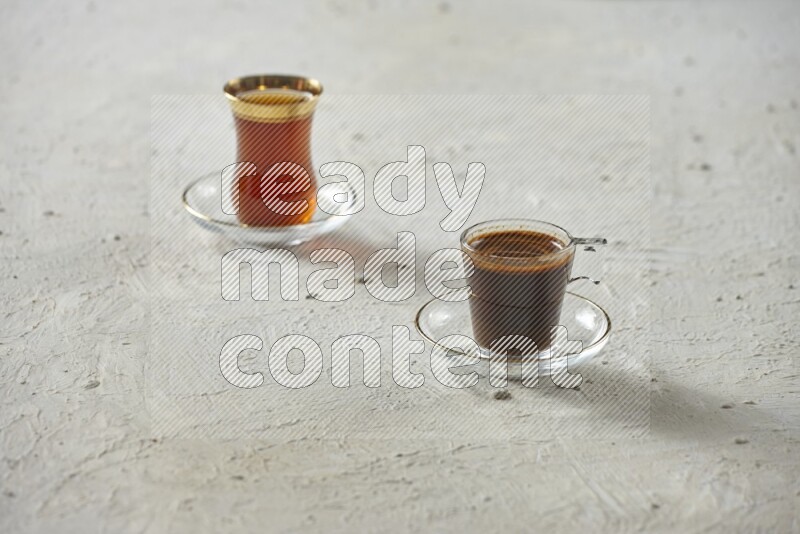 A coffee glass cup with dates and tea on textured white background