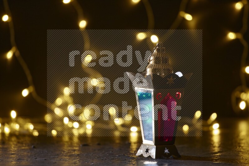 A traditional ramadan lantern surrounded by glowing fairy lights in a dark setup