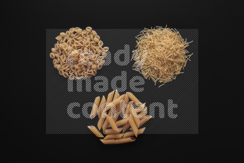Different pasta types in bunches on black background