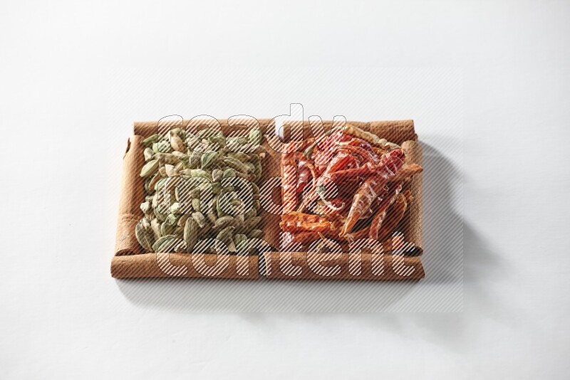2 squares of cinnamon sticks full of cardamom and dried red chilis on white flooring