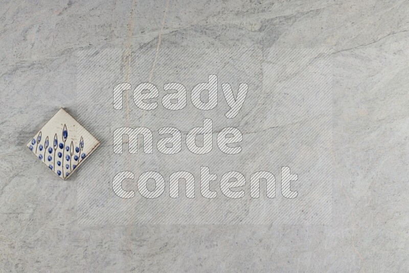 A decorative pottery coaster on grey marble background