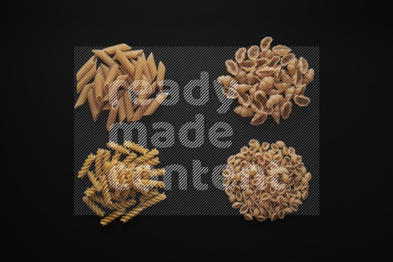 Different pasta types in bunches on black background