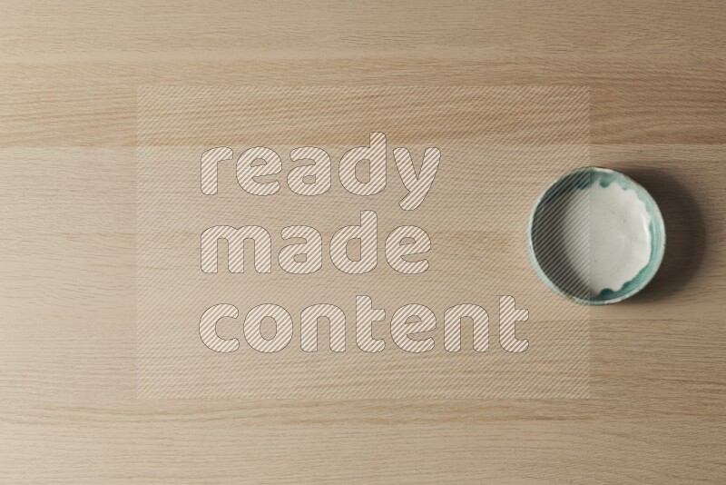 A multicolored pottery bowl on light wooden background