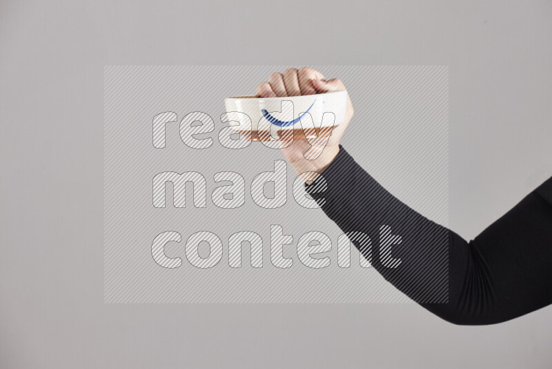 A woman in black abaya holding different pottery essentials in different positions
