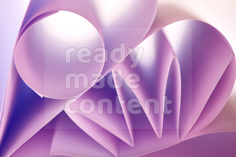 An artistic display of paper folds creating a harmonious blend of geometric shapes, highlighted by soft lighting in purple tones