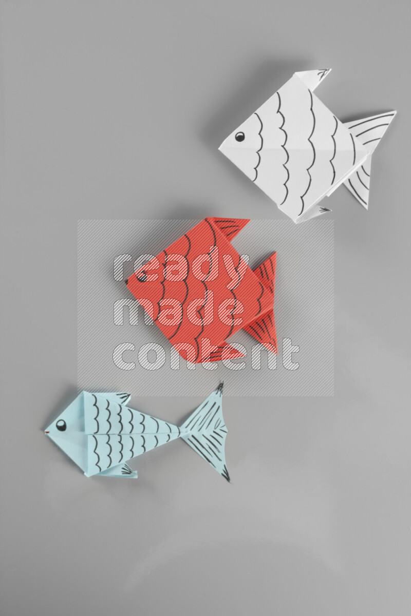Origami fish on grey background