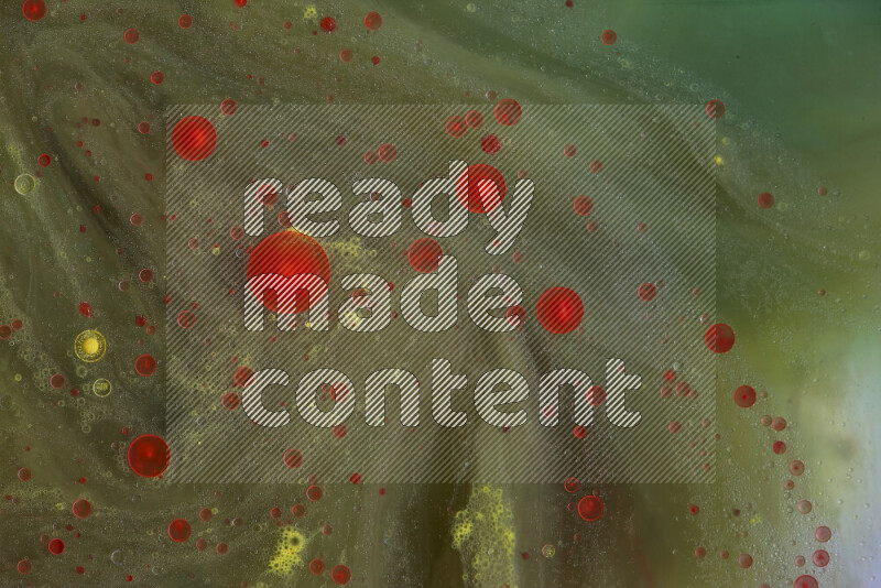 The image captures a dramatic splatter of red, green and yellow paints over the backdrop