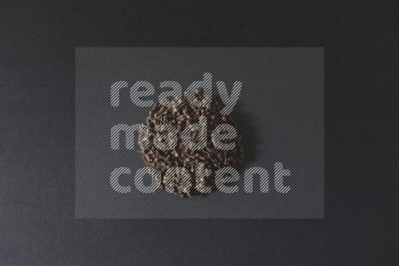 Cloves in a circle shape on a black flooring