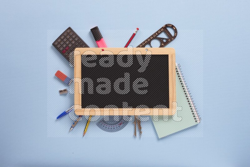 A blackboard with assorted school supplies on blue background