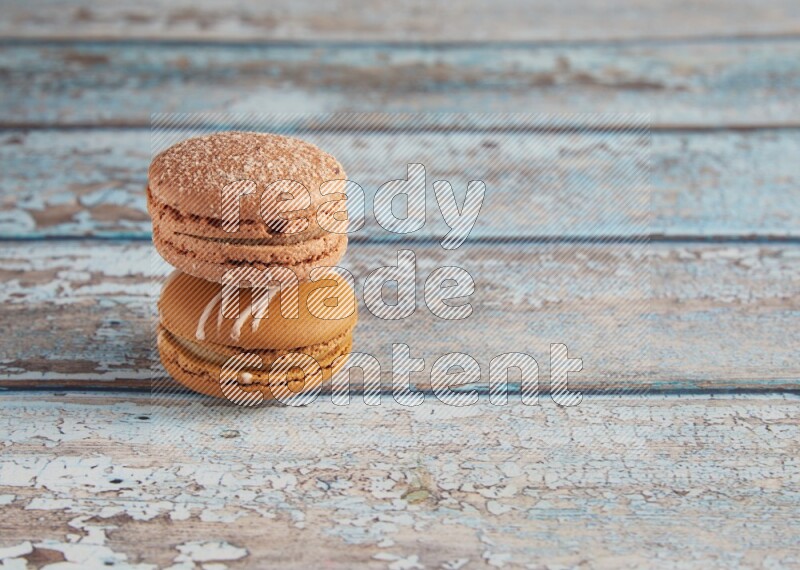 45º Shot of of two assorted Brown Irish Cream, and Brown Hazelnuts macarons  on light blue background