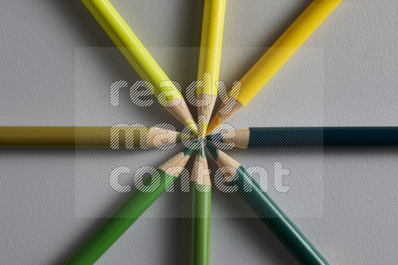 An arrangement of colored pencils in different colors on grey background