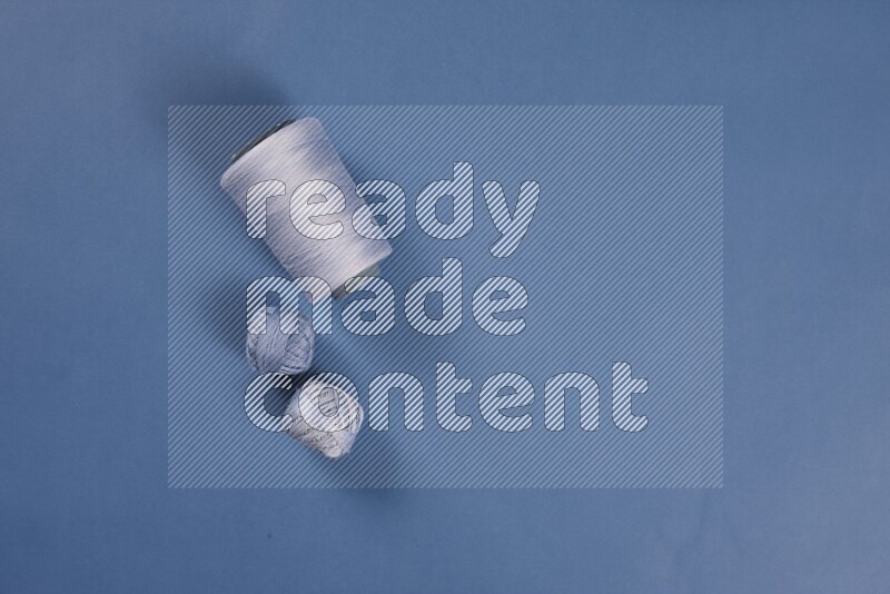 A blue collection of sewing and tailoring tools arranged on a blue background