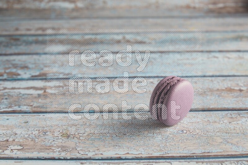 45º Shot of Purple Blueberry macaron on light blue wooden background