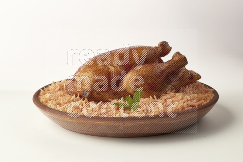 red basmati Rice with whole roasted chicken on a pottery plate direct on white background