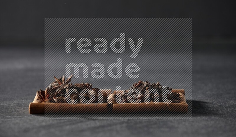 2 squares of cinnamon sticks full of star anise and cloves on black flooring