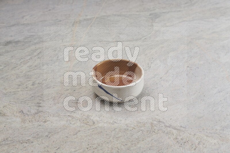 A multicolored pottery bowl on grey marble background