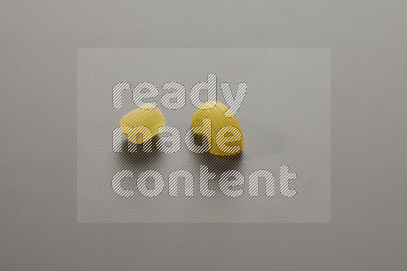 Big rings pasta with other types of pasta on grey background