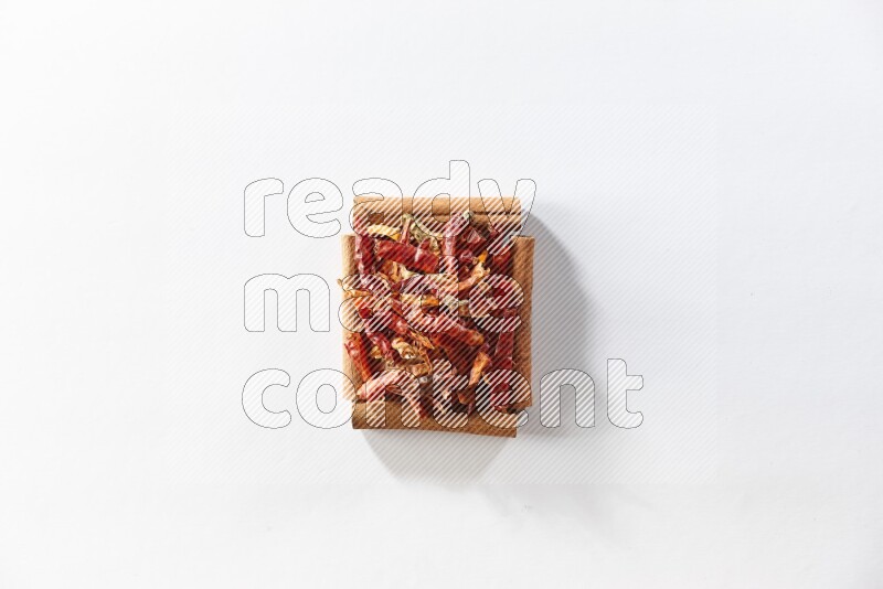 A single square of cinnamon sticks full of chilis on white flooring