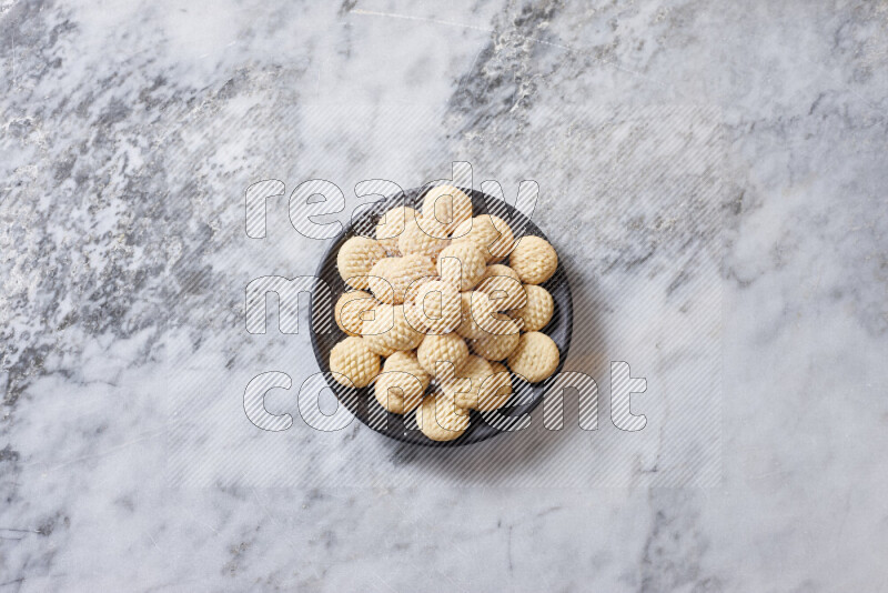 Kahk in black pottery plate on grey marble background