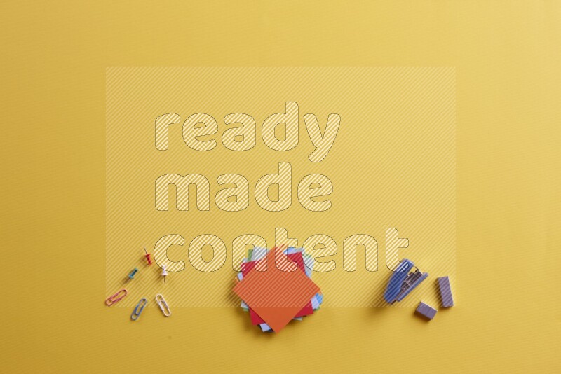 ورق ملاحظات متعدد الألوان مع مستلزمات مدرسية على خلفية صفراء