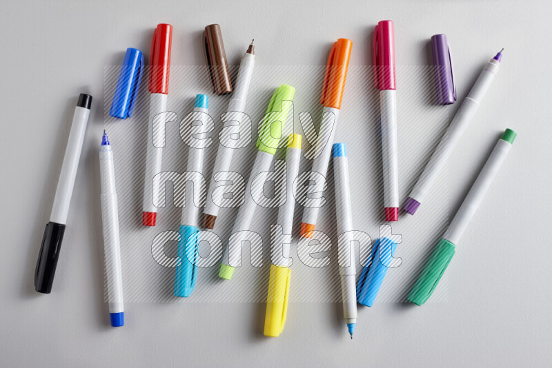An arrangement of coloring pens in different colors on grey background