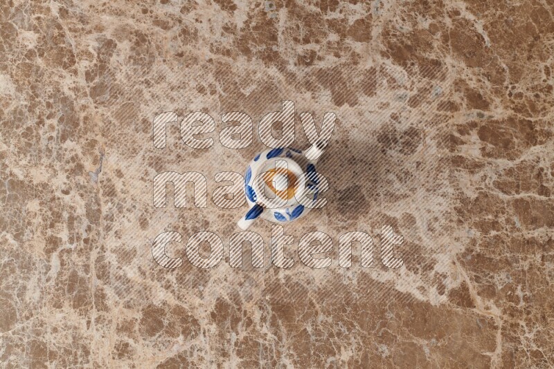 إبريق شاي فخاري على خلفية رخام بيج