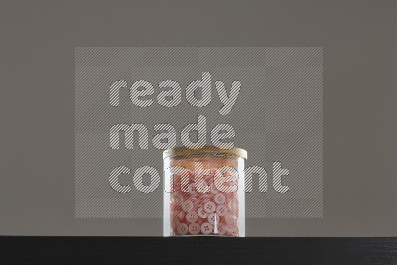 Buttons in a glass jar on black background