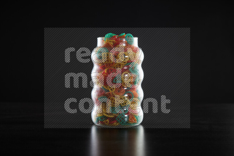Snacks in a glass jar on black background