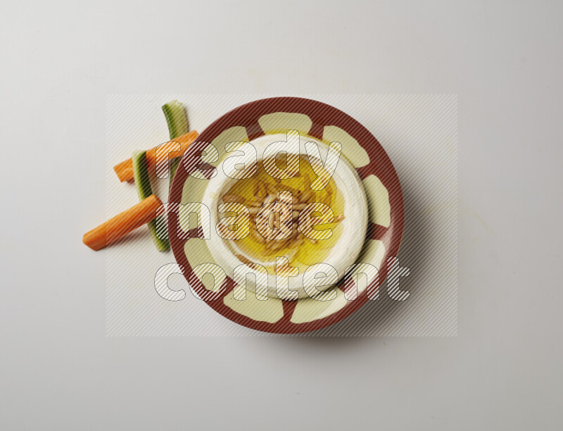 Lebnah garnished with pine nuts in a traditional plate on a white background