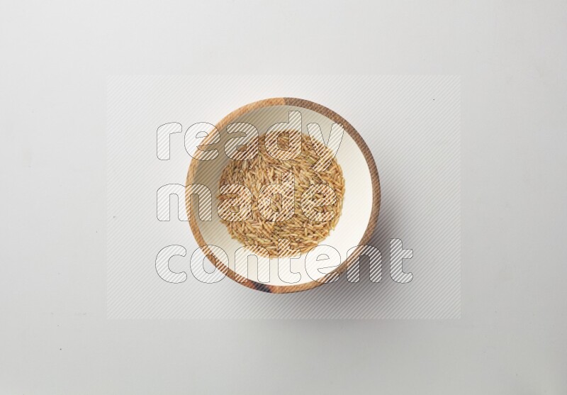 Top-view shot of long grain brown rice in a container on white background