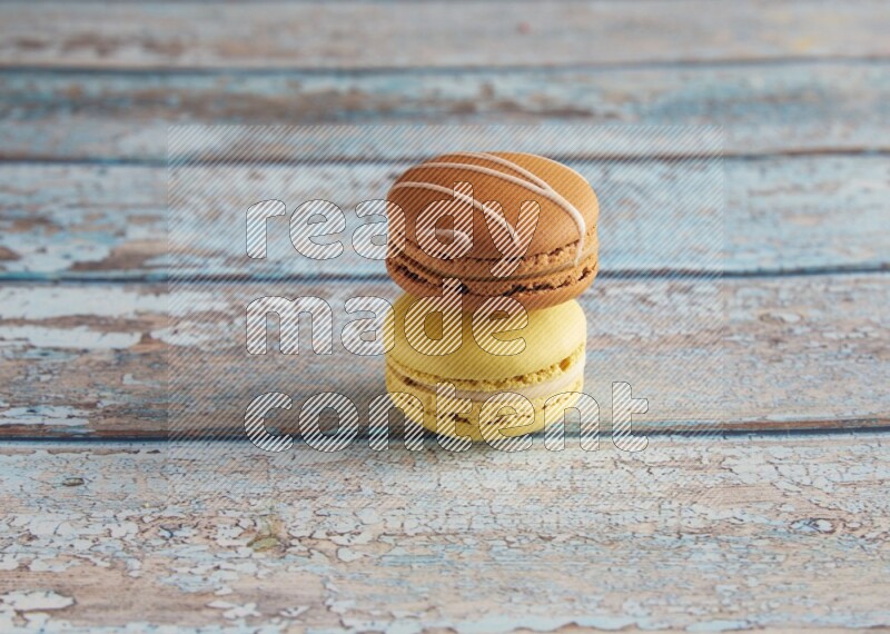 45º Shot of of two assorted Brown Irish Cream, and Yellow Lime macarons on light blue background