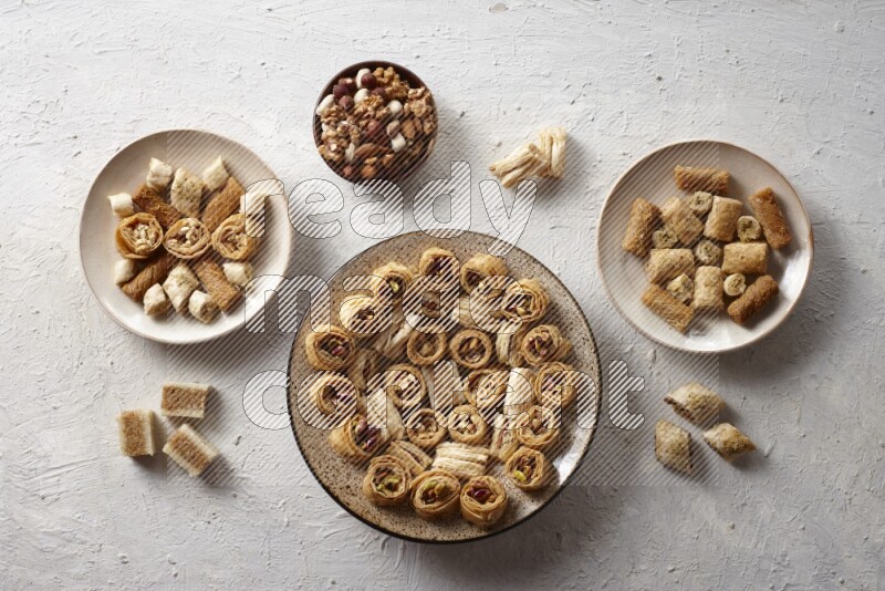 Oriental sweets in pottery plates with nuts in a light setup