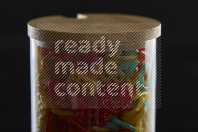 Snacks in a glass jar on black background