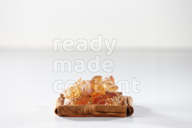 A single square of cinnamon sticks full of Arabic gum on white flooring
