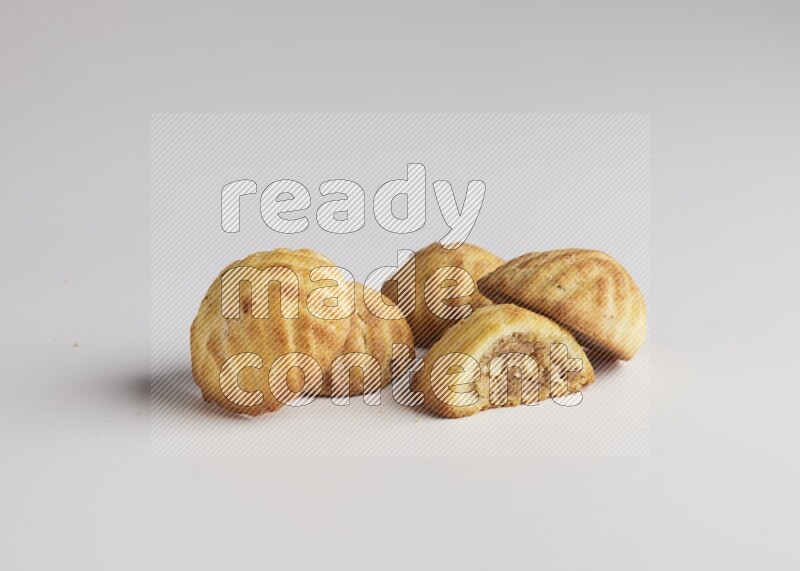 Five Pieces of Maamoul filled with walnut paste  one of them is cut with direct on white background