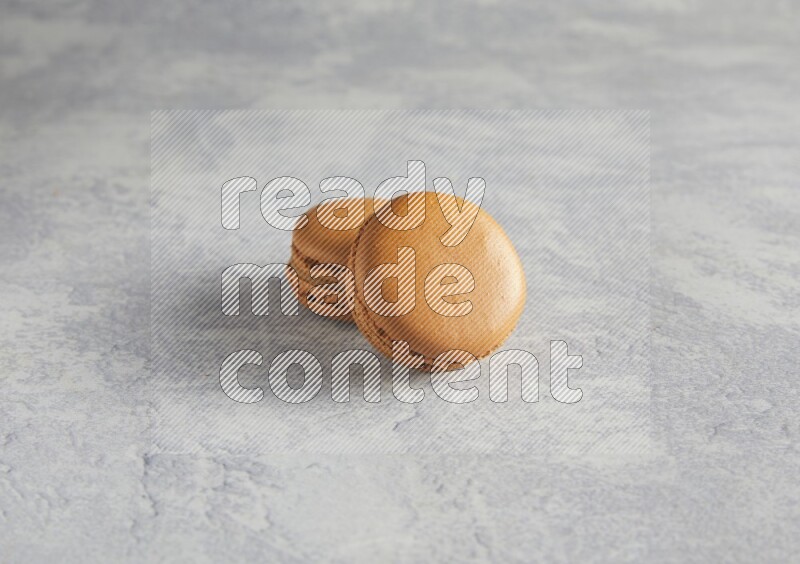 45º Shot of two Brown Maple Taffy macarons  on white  marble background