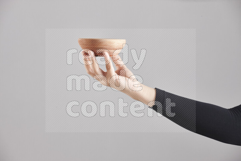 A woman in black abaya holding different wooden essentials in different positions
