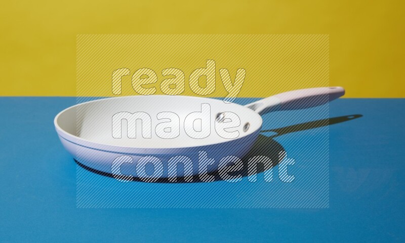 white pan on yellow and Blue background