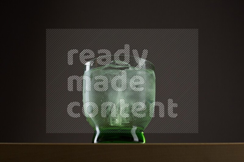 Low angle shot of a glass of water and ice on grey background