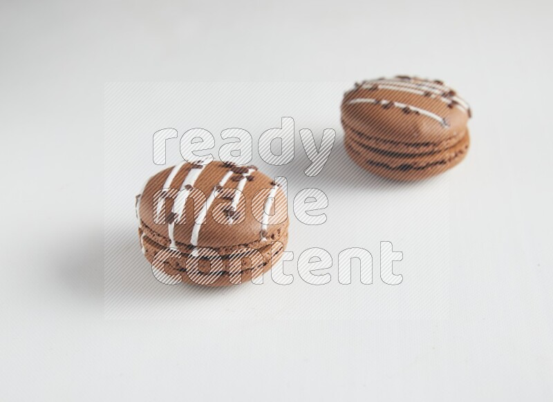 45º Shot of two Brown white Chocolate Caramel macarons on white background