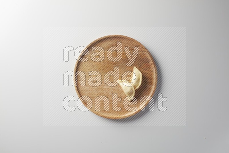 Two Sambosas on a wooden round plate on a white background